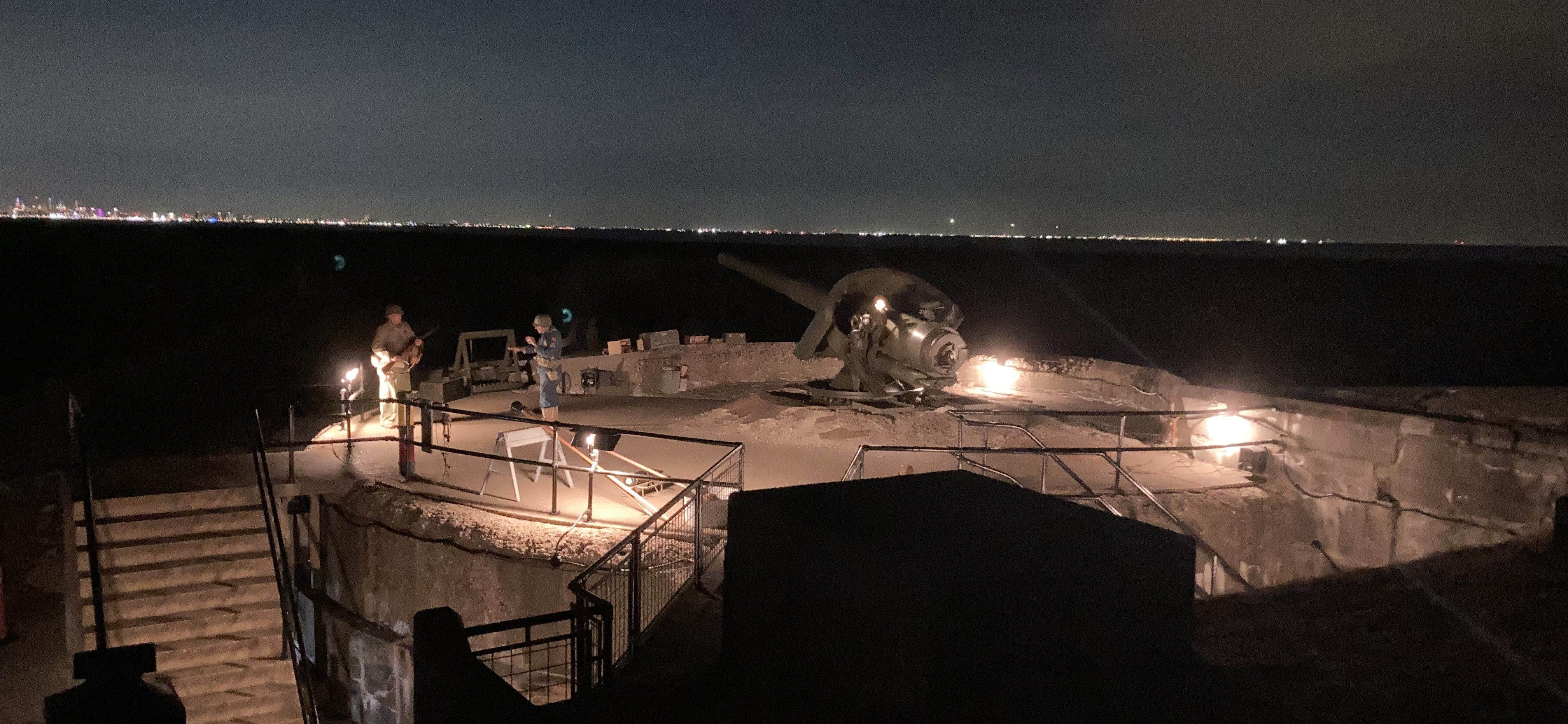View of a gun battery at night illuminated by period lighting